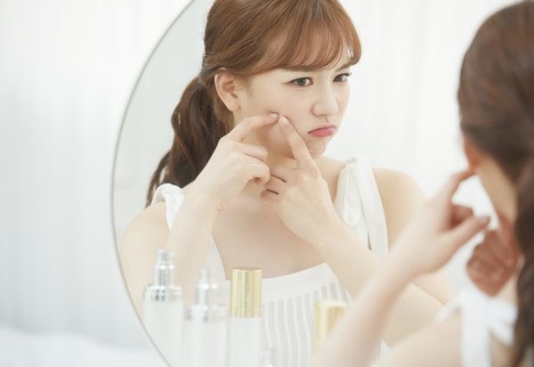 鏡越しに肌の調子を確認する女性