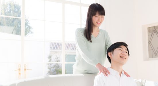 女性にマッサージをされている男性