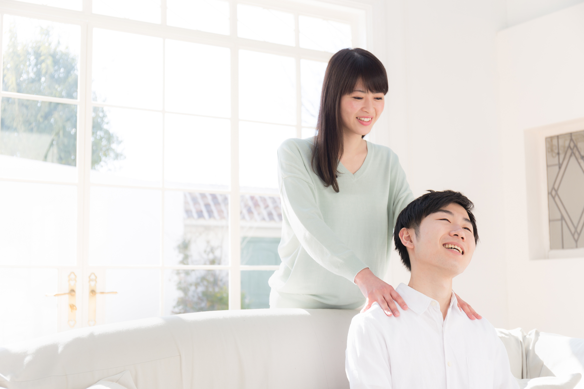 女性にマッサージをされている男性