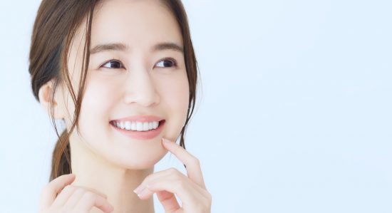笑顔で顔を触る余生