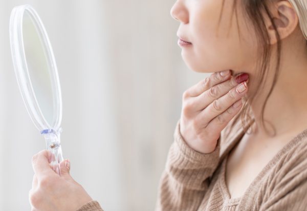 鏡で二重あごを確認する女性