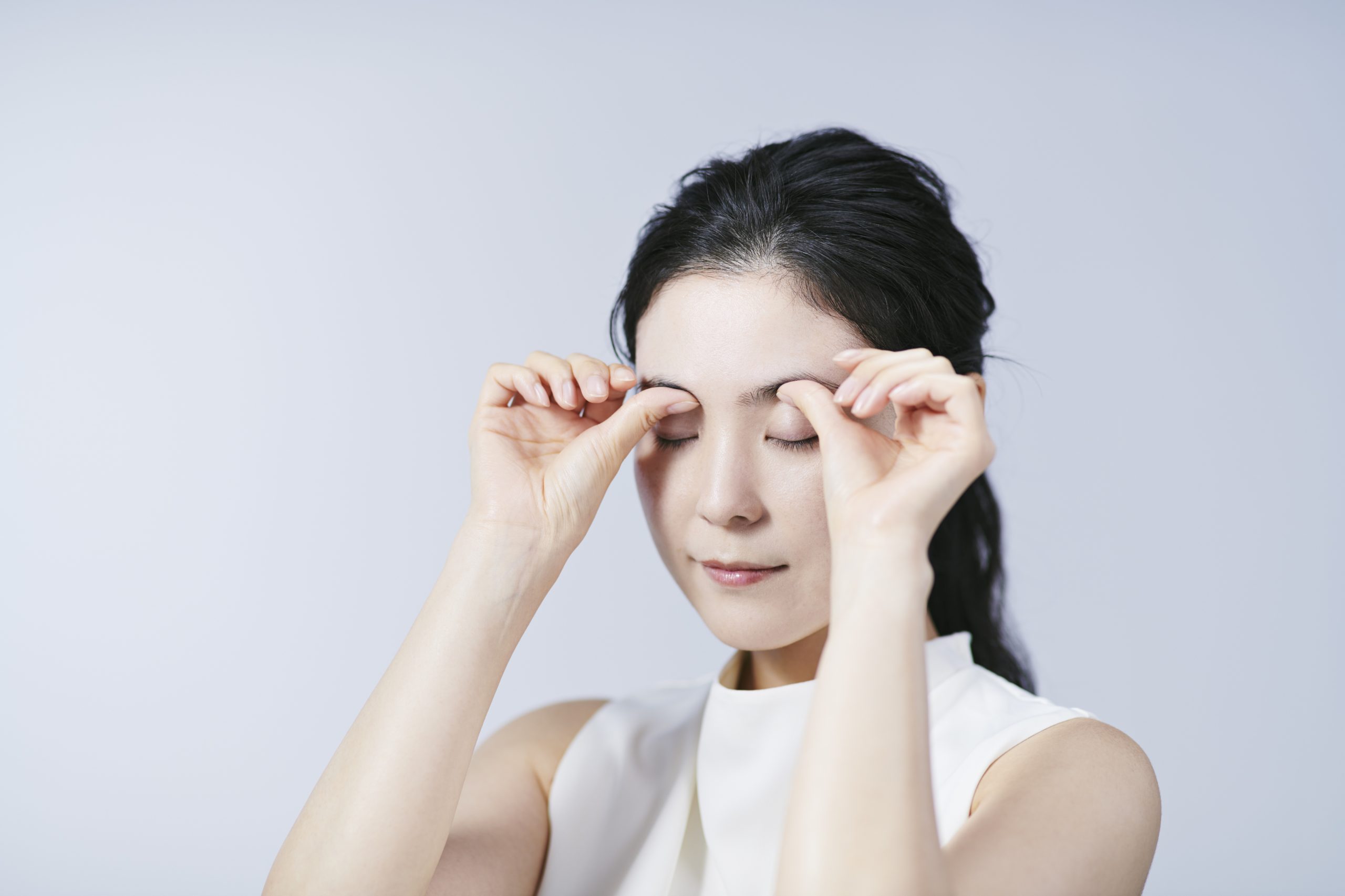 眉毛をマッサージする女性