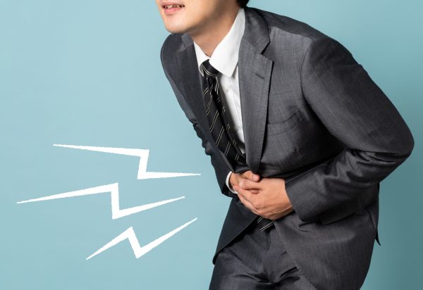 お腹が冷えて腹痛に襲われる男性