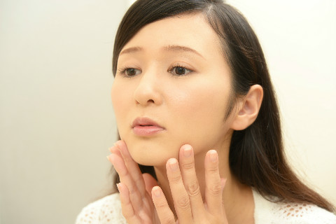 顔の歪みを気にする女性