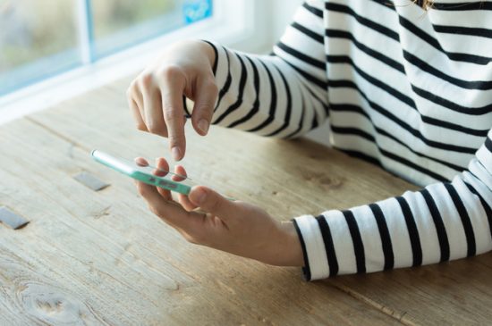 スマホで整体院を検索する女性